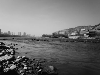 Scenic view of lake by city against clear sky