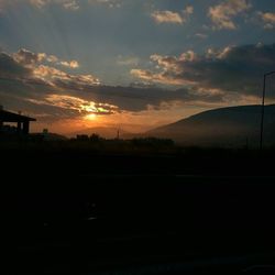 Silhouette of landscape against cloudy sky