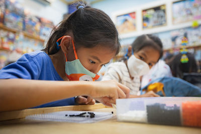 Girl playing at school wearing protective face mask