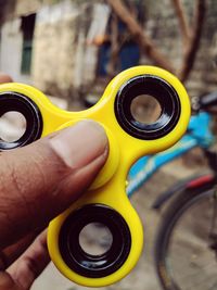 Cropped hand holding yellow fidget spinner