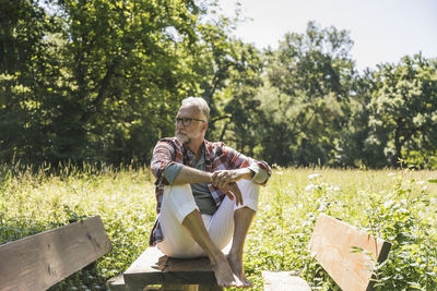 Senior man sitting on picnic table in park