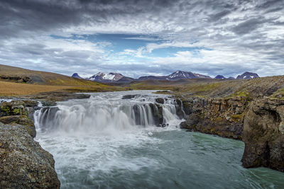 Scenic view of waterfall against sky