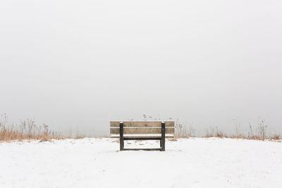 Empty bench on wintry lakeshore