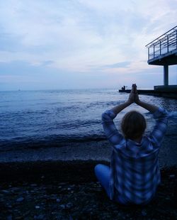 Rear view of man looking at sea against sky