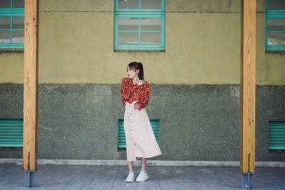 Rear view of woman standing against wall