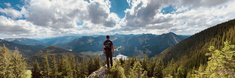 Panoramic view of man standing by mountains against sky