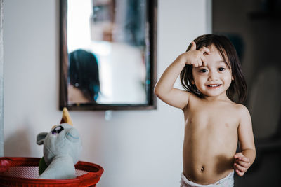 Portrait of smiling cute girl standing at home