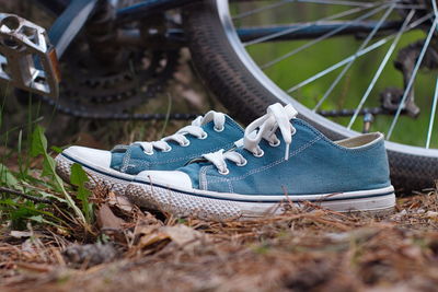 Close-up of canvas shoes against bicycles on field