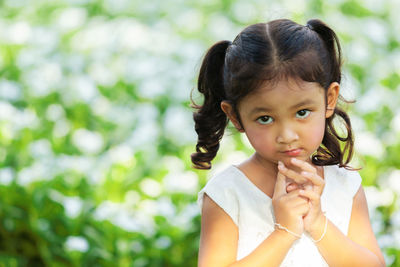 Portrait of cute girl holding camera outdoors