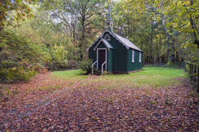 Built structure on field by trees in forest