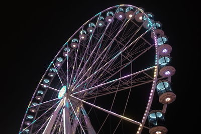 Low angle view of illuminated ferris wheel against sky at night