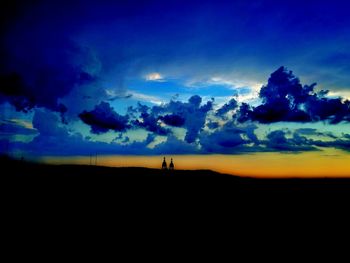 Silhouette landscape against blue sky during sunset