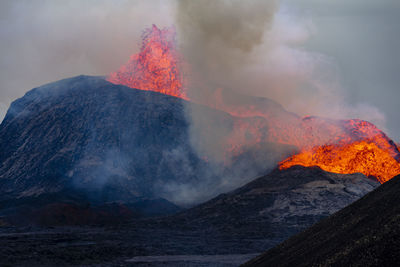 Scenic view of an active volcano against sky