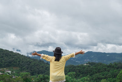 Rear view of woman standing against sky