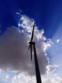Low angle view of wind turbine against blue sky