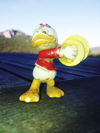 Close-up of yellow toy statue on table