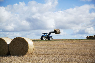 Hay bales on field against sky