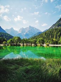 Scenic view of lake by mountains against sky