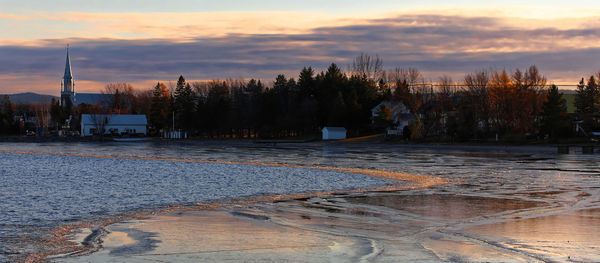 Scenic view of frozen lake against sky during sunset