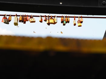 Low angle view of love locks hanging on bridge