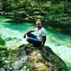 Portrait of man sitting on rock