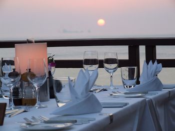 View of wine glass on table at restaurant during sunset