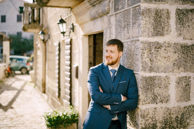 Young man standing against wall