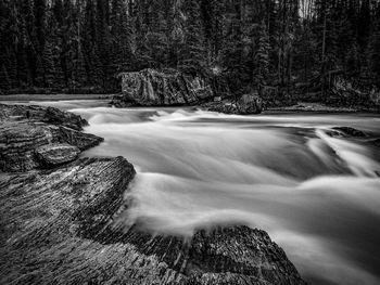Scenic view of stream flowing through rocks in forest