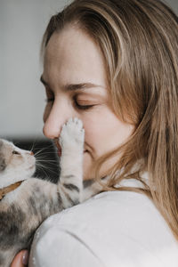 Cat adoption, adopt kitten from rescues and shelters. portrait of woman playing with outbred