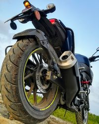 Low angle view of motorcycle on field against sky