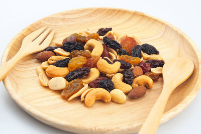 High angle view of dried fruits in wooden plate on gray background