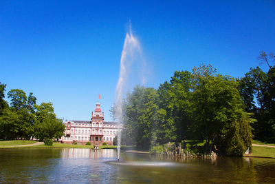 Fountain in lake against sky