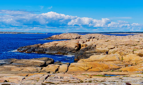 Sailboat in the distance along the rocky coastline of asmaløy in hvaler, norway 