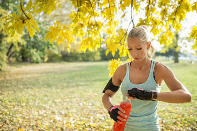 Woman holding drink bottle in park