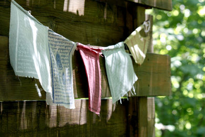 Prayer flags hanging on clothesline by wooden house