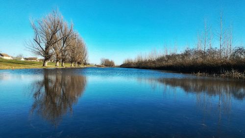 Scenic view of lake against clear blue sky