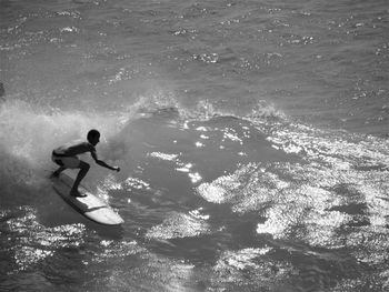 Man surfing on waves in sea