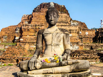 Statue against temple against sky