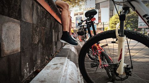 Bicycle parked on footpath by wall