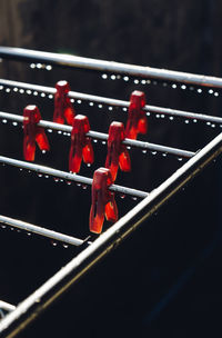 Clothespins hanging on wet metallic rod