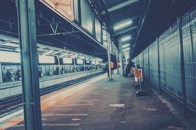 Rear view of people walking on railroad station platform