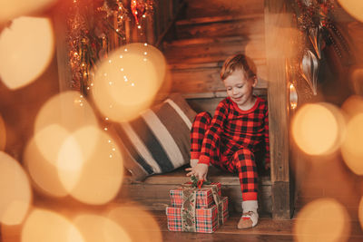 Portrait of woman holding illuminated christmas tree