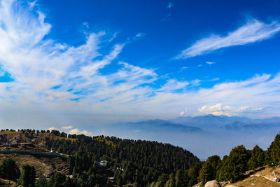 Scenic view of mountains against blue sky