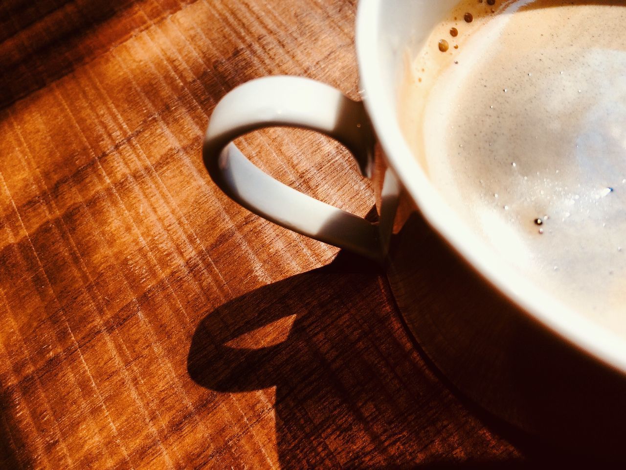 HIGH ANGLE VIEW OF COFFEE CUP ON WOODEN TABLE