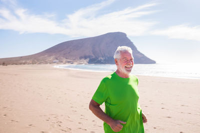 Senior man jogging at beach
