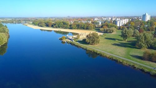 Scenic view of river by buildings against sky