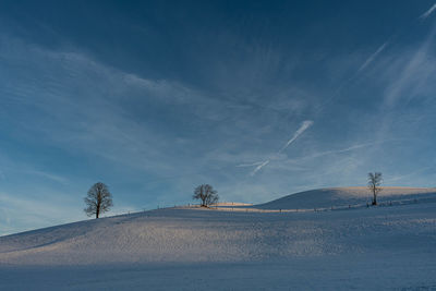 Scenic view of snowcapped mountains against blue sky