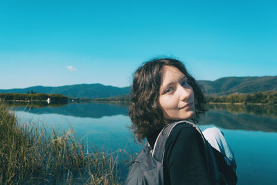 Portrait of woman in lake against sky
