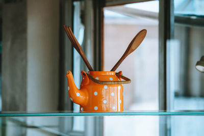 Close-up of orange  tea pot on table