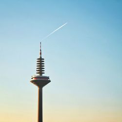 Low angle view of communications tower against sky